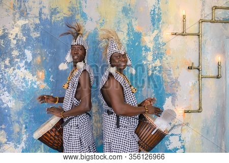 A Group Of People In Traditional African Costumes Playing Jembe Drums