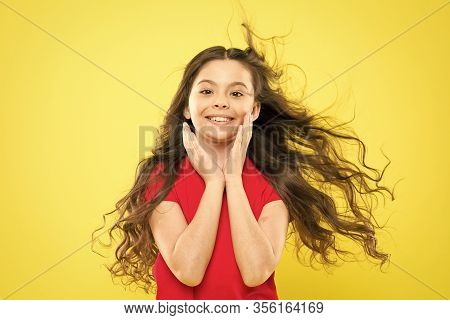 Girl Adorable Kid Long Wavy Hair Yellow Background. Wind Can Also Damage Hair. Strong Persistent Win