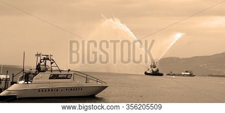 Trieste Italy 05 19 2019: Deneb Tug Boat In Trieste Italy Giving Farewell Salute With Fire Hoses Wit