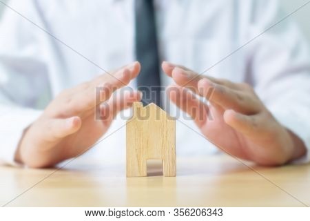 Insurance Home Protection Concept. Man Hands Prevent Wooden House