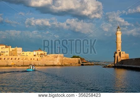 Fishing boat going to sea in picturesque old port of Chania is one of landmarks and tourist destinations of Crete island in the morning. Chania, Crete, Greece