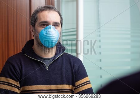 Worried Man With Medical Mask Looking On The Mirro