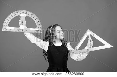 Smart And Clever Concept. Girl With Big Ruler. School Student Study Geometry. Kid School Uniform Hol