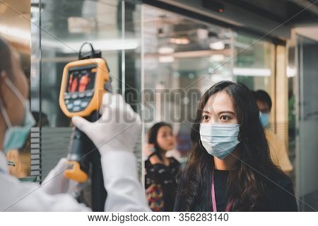 People Waiting For Temperature Check By Thermoscan