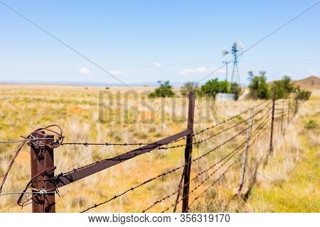 Windmill On A Farm In Rural Grassland Area Of South Africa
