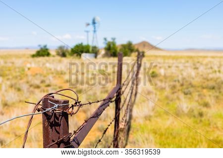 Windmill On A Farm In Rural Grassland Area Of South Africa