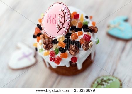 Homemade Easter Cake And Gingerbread Cookies Decorated With Fruits And Nuts On A Wooden Background