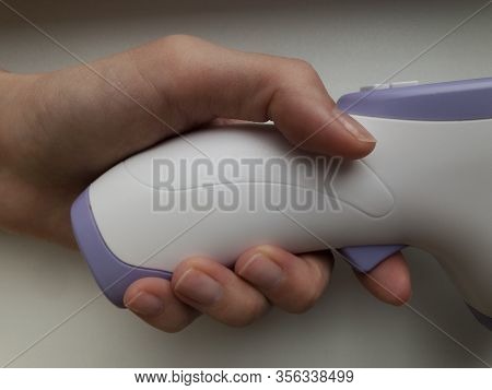 Electronic Thermometer In Hand. Is Used To Measure A Patient's Temperature In A Hospital.