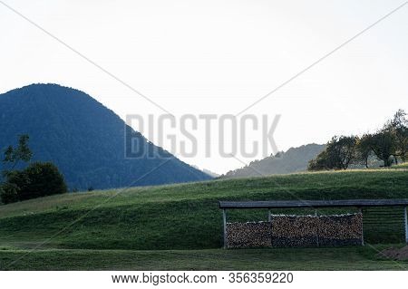 Hayrack Stacked With Wooden Logs In Nature