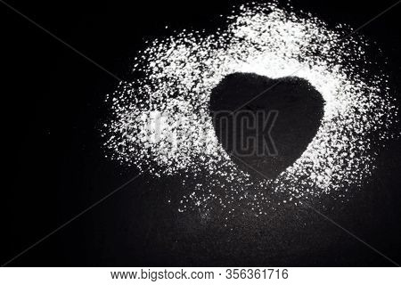 Trace Of Powdered Sugar From A Heart-shaped Biscuit. Black Background.