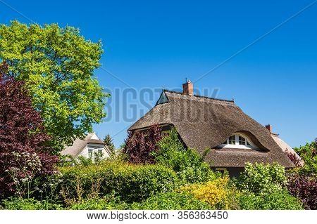 Building, Trees And Blue Sky In Wieck, Germany.