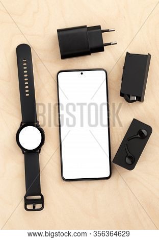 Smartphone And Watch On A Wooden Table With A White Screen. Smart Watch And Smartphone With A Blank 