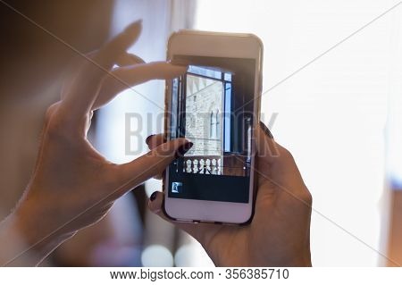 Girl Holds A Smartphone In Her Hands And Shoots A Video In The Palazzo Vecio. The Concept Of Tourism