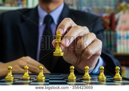 Chess Game On Chess Board Behind Business Man Background. Business Concept To Present Financial Info