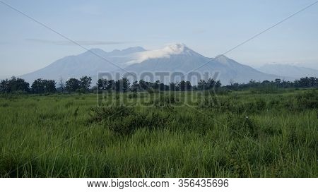Groups Of Mountain Cloudy View Over Green Grassland