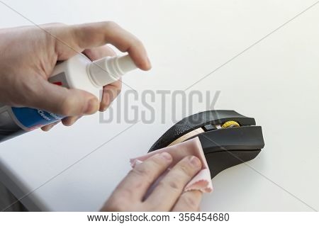 A Man Wipes A Dirty Mouse With A Rag . Cleaning The Computer Mouse. Removing Microbes With An Alcoho