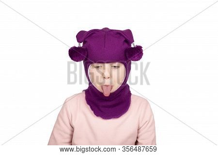 Funny Little Girl In Purple Wool Winter Balaclava Or Knitted Cap Making Funny Faces. Gigl In Winter 