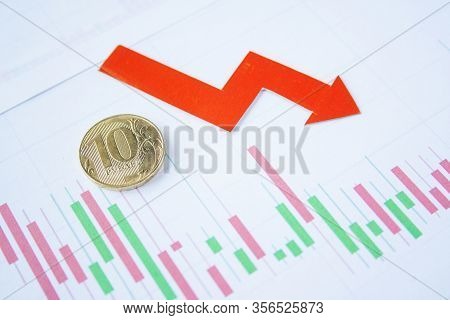 Ten Rouble Coin On Currency Graph With Red Arrow Down. Exchange Rate Chart. Ruble Depreciation. Exch