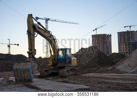 Track-type Excavator During Earthmoving At Construction Site. Backhoe Digg Ground At Construction Si