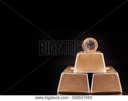 One Real Coin And Gold Bars. Grand Prize Or Big Luck Concept. Coin Of Brazil On Isolated Black Backg