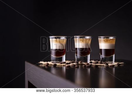Three Shots Of B-52 Cocktail Placed In A Row On A Bar Counter With Copy Space