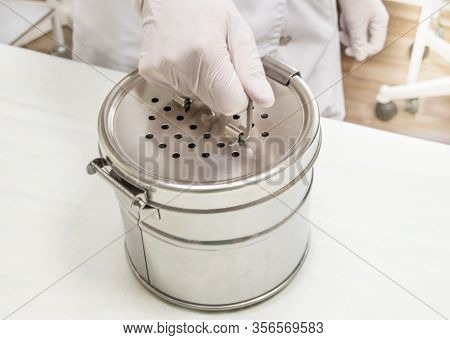 Round Stainless Steel Sterilizer In The Hands Of A Nurse In Rubber Gloves. Preparation For Autoclave