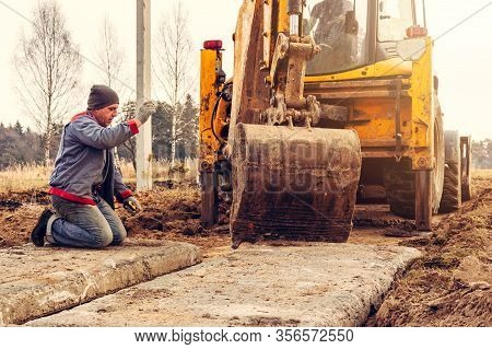 The Excavator Installs Concrete Slabs For The Road.