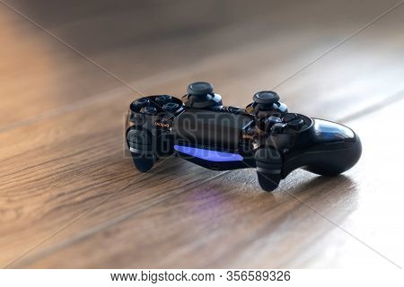 Brecht, Belgium - Februari 1 2020: A Portrait Of A Turned On Playstation 4 Controller With A Blue Li