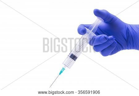 Hand In A Blue Medical Glove Holds A Syringe With A Needle, Isolated Object, White Background