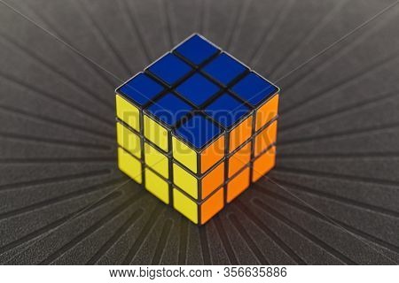 BUDAPEST, HUNGARY - CIRCA 2019: Solved Rubik's cube logic game on dark background evenly lit from all sides