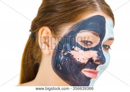 Woman With Clay Carbo Black Mask On One Half Face And White Mud On Second Half. Girl Removing Cosmet
