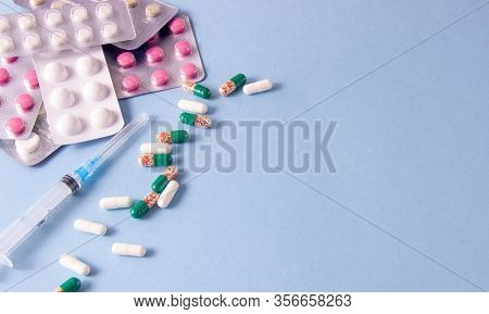 Coronavirus Phrase Text On A Blue Background With Medicines And A Syringe. New Coronavirus 2019-ncov