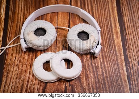 Need A Replacement Embouchures On Old White Earbud. Repair Accessories.wooden Background