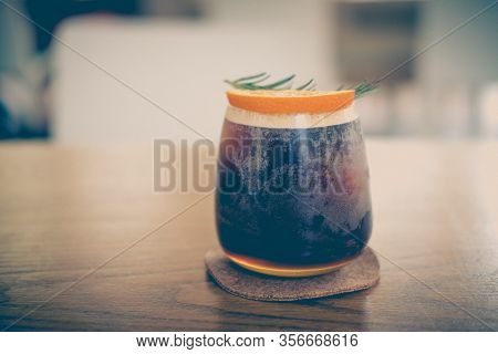 Glass Of Espresso Shot Mixed With Orange Juice On Wood Table. Refreshing Summer Drink Concept