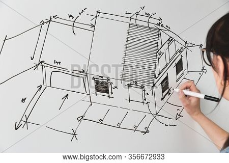 Close-up Of A Young Female Architect Drawing A Sketch For A New Famaly Home Project. Concept Of Work