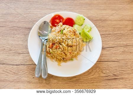 Fried Rice Placed On A Wooden Table With Cucumbers And Tomato