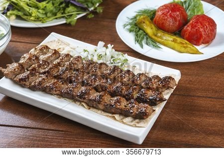 Fast food. Eastern food. Shish kebab, lyulya-kebab. Dishes of oriental cuisine lying in plte and dec