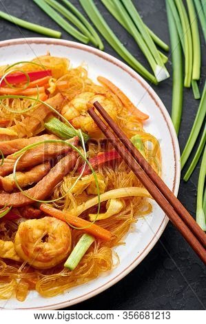 Singapore Mei Fun In White Plate On Dark Slate Background. Singapore Noodles Is Chinese Cuisine Dish