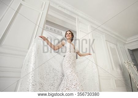 Beautiful Bride Posing In Wedding Dress In A White Photo Studio. Mirror. Sofa. Bouquet. The Door. Ch