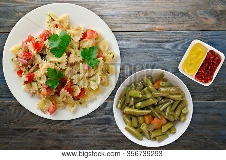 Pasta On A White Plate. Pasta Tomatoes, Onions, Cabbage On A Blue Wooden Background. Pasta With Vege