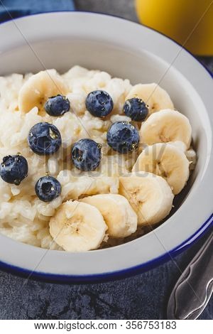 Close Up Of Milk Rice Porridge With Blueberry And Banana, Creamy Rice Pudding Or French Riz Au Lait 