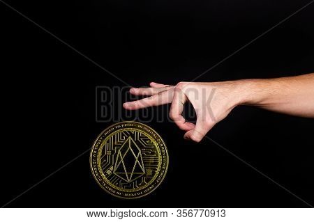 The Symbol Of The New Popular Cryptocurrency Eosio With The Image Of Hands On Dark Background
