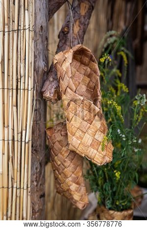 Bast Shoes Hanging On Wall In Kernave Days Of Live Archeology. Bast Shoes Were Traditional Lithuania