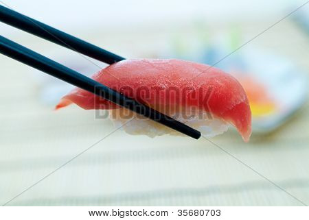 Sushi con le bacchette, con un fondo schiena