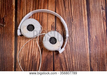 Need A Replacement Embouchures On Old White Earbud. Repair Accessories.wooden Background
