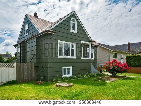 Old But Neat Residential House With Concrete Pathway To The Entrnace