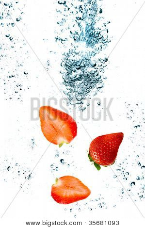 Strawberry are falling in water with a big splash