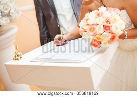 Bride And Groom Signing Marriage Wedding Certificate At Registry.