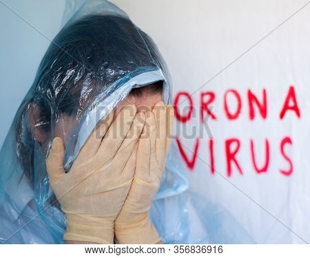 Woman In A Protective Suit Closing Her Face. Inscription Coronavirus In The Background. Coronavirus 