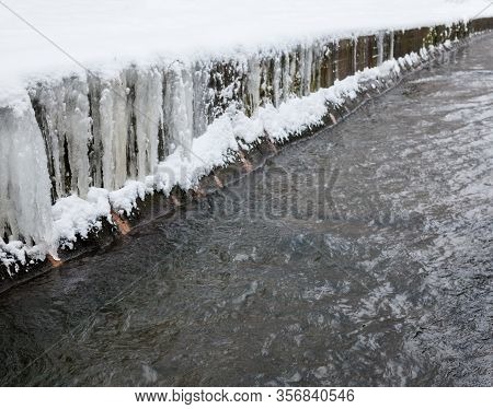 Urban Stream In Winter. Icicles On Concrete River Banks. The Lybid River (kyiv, Ukraine) In The Snow